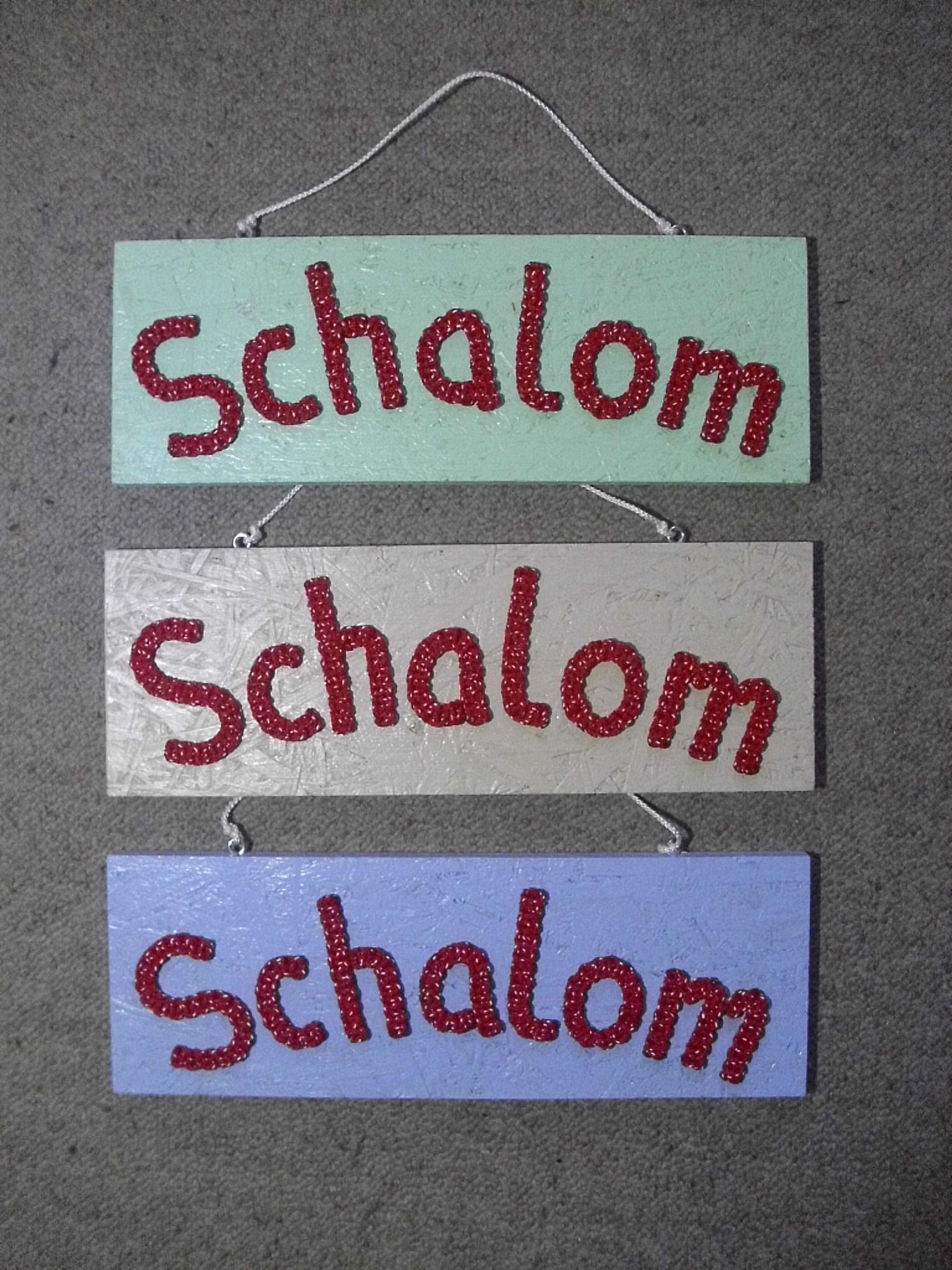 SPRUCHHOLZ SCHALOM, geknotete Schrift auf Holz,jeweils  ca. 28 x 10 cm, 24,- €, Best.Nr. 034. Bitte gewünschte Farbe angeben.